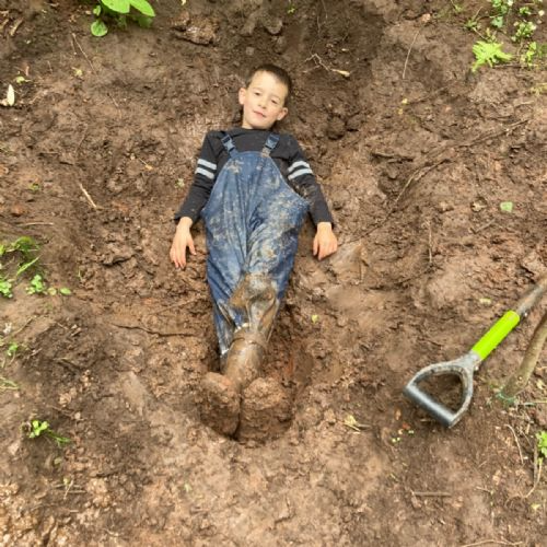 Pupil laying in a hole he has dug