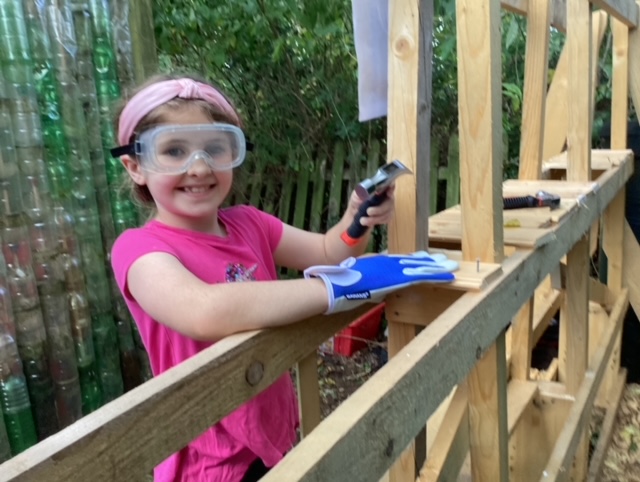 Pupil with safety gear using tools to make a bug hotel
