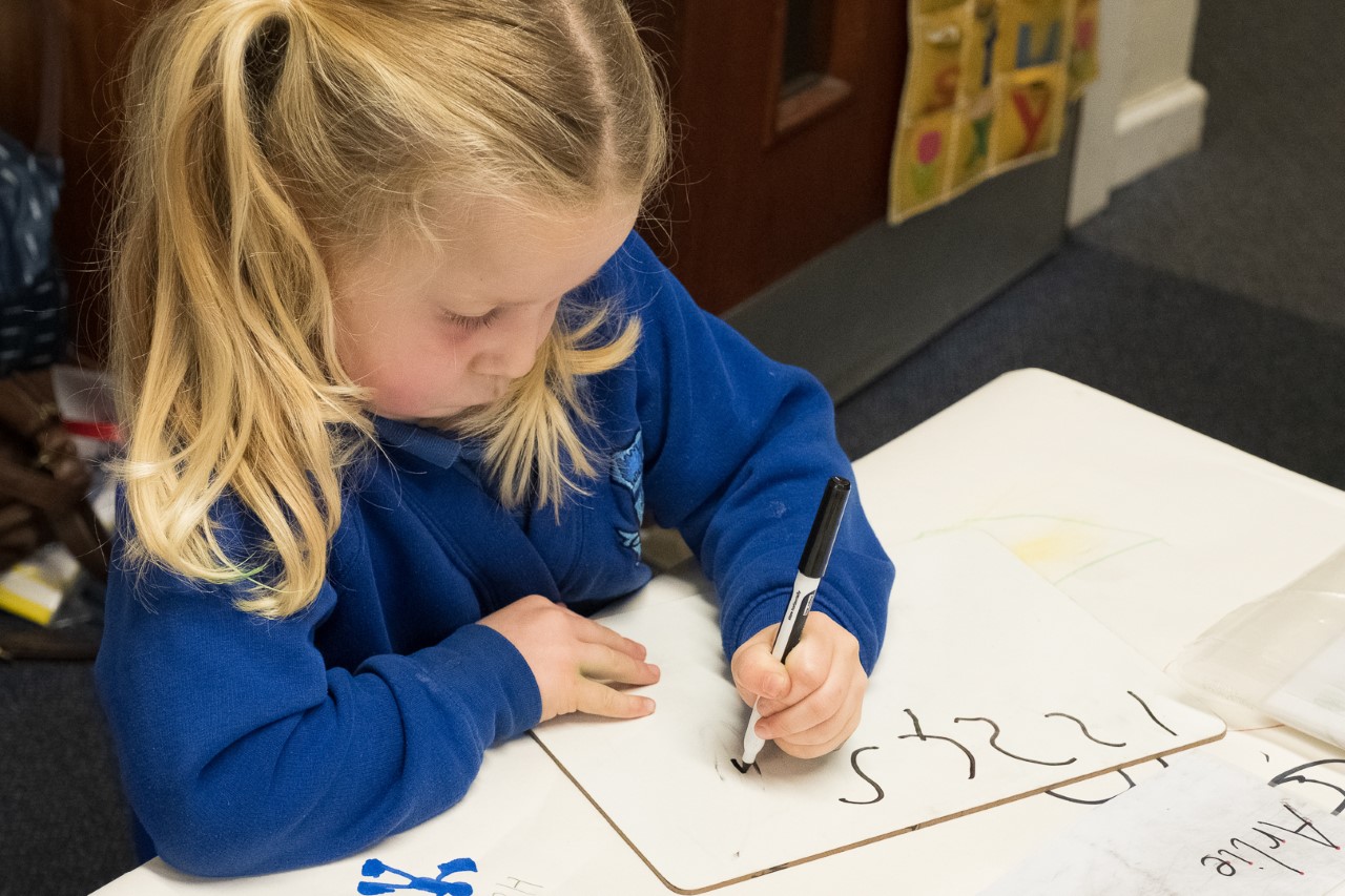 Early years pupil writing numbers