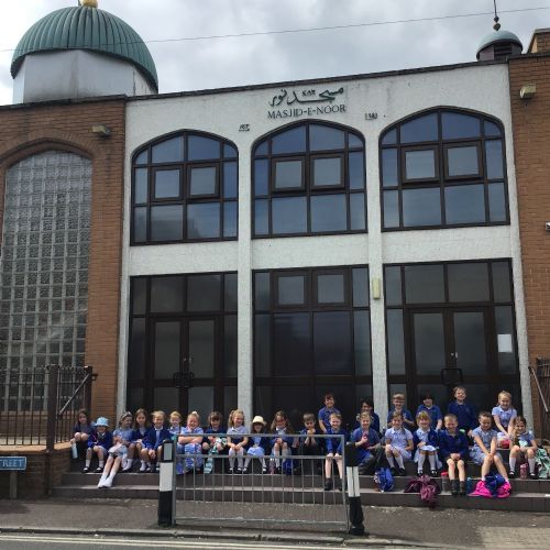 Pupils sat outside a Mosque on one of our school trips