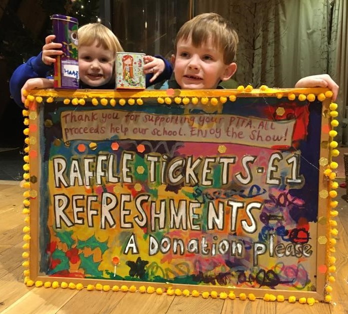 Homemade sign advertising our raffle with two pupils who helped make it