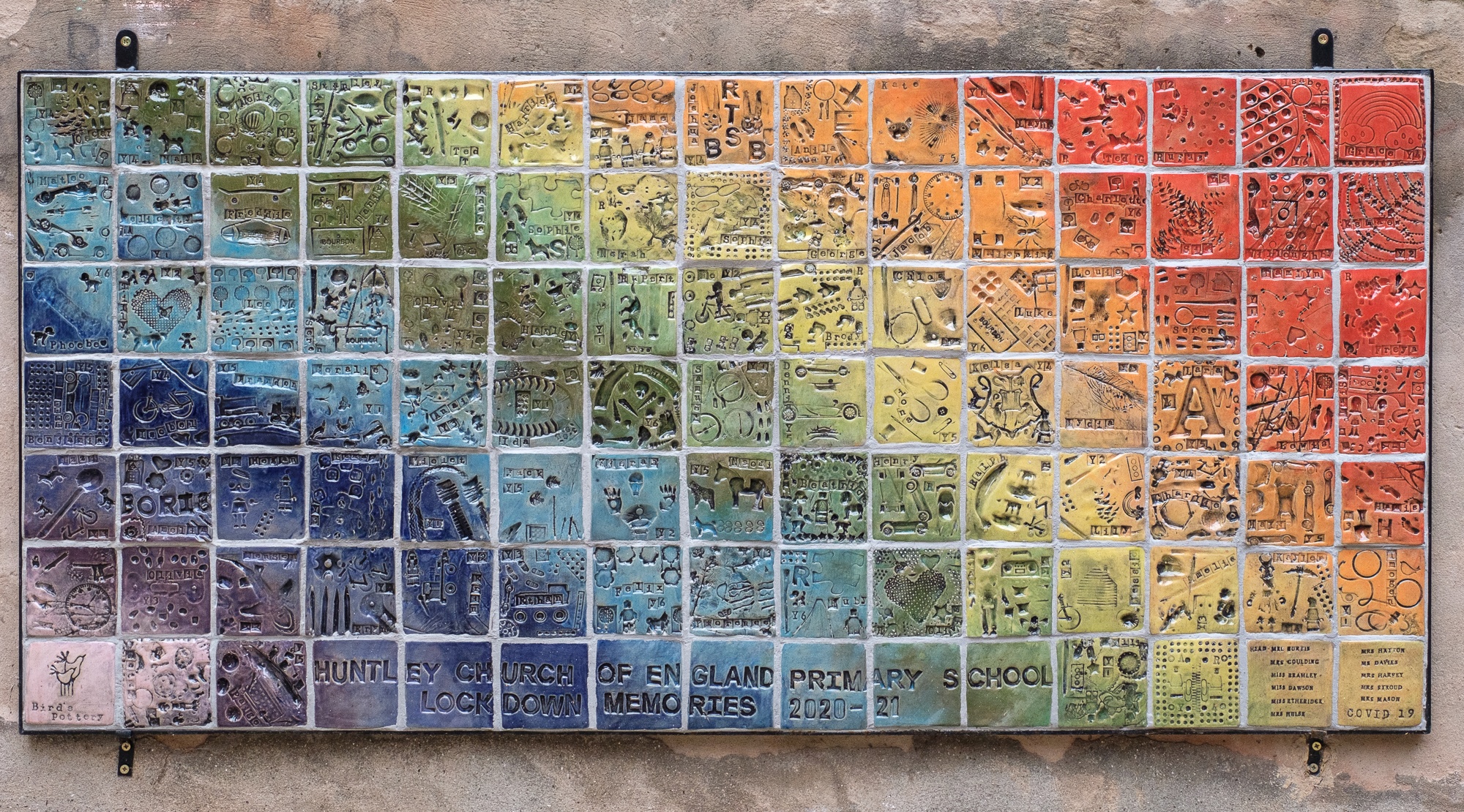 Covid Lockdown Memory Wall rainbow coloured clay tiles made by each child with imprints of items they associated with lockdown