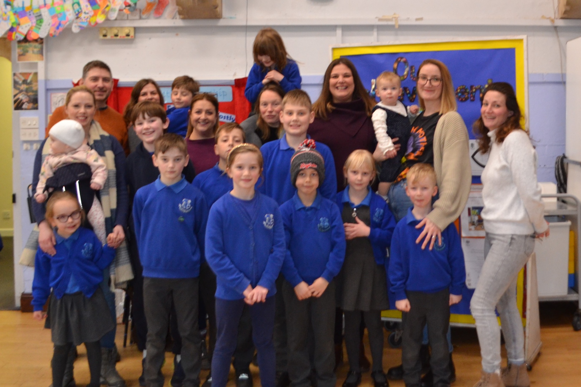 Photo of 8 members of the PTFA with 11 of their children who attend the school