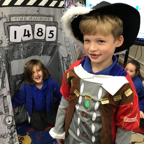 Pupil in fancy dress by a time machine during a History lesson